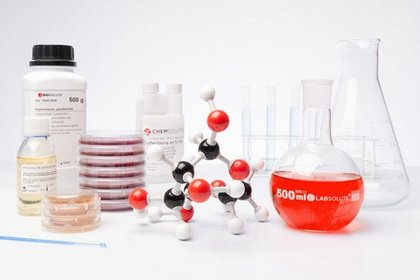 Laborgeräte und Chemikalien, darunter ein Molekülmodell, Petrischalen, Flaschen und Reagenzgläser