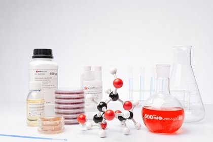 Laborgeräte und Chemikalien, darunter ein Molekülmodell, Petrischalen, Flaschen und Reagenzgläser