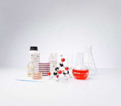 Laborgeräte und Chemikalien, darunter ein Molekülmodell, Petrischalen, Flaschen und Reagenzgläser