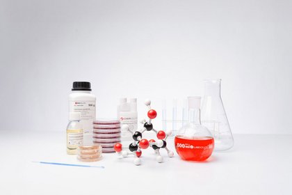 Laborgeräte und Chemikalien, darunter ein Molekülmodell, Petrischalen, Flaschen und Reagenzgläser