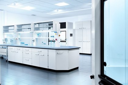 Helles steriles Labor mit moderner Laboreinrichtung von Köttermann, weißen Schränken und Arbeitsflächen und verschiedenen Laborgeräten