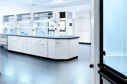 Helles steriles Labor mit moderner Laboreinrichtung von Köttermann, weißen Schränken und Arbeitsflächen und verschiedenen Laborgeräten