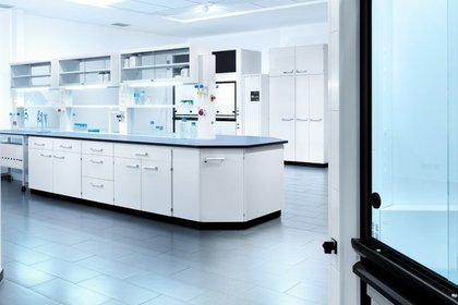 Helles steriles Labor mit moderner Laboreinrichtung von Köttermann, weißen Schränken und Arbeitsflächen und verschiedenen Laborgeräten