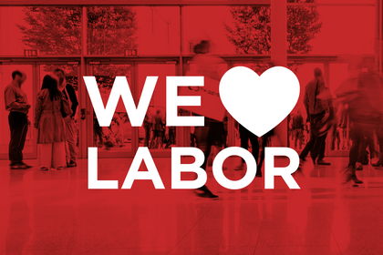We love Labor Schriftzug mit Herzsymbol vor einer Messehalle Weitere Zeilen anzeigen